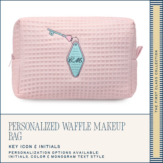 Pink waffle-textured makeup bag with a decorative key and initials on a white background